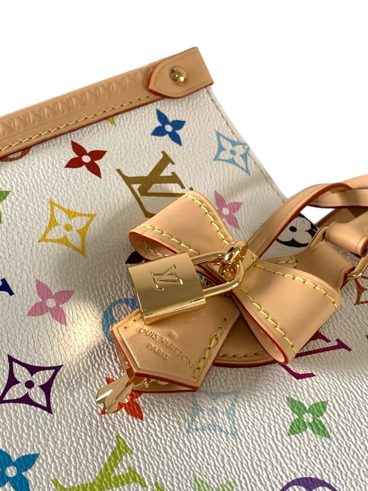 SWORD LUXURY beyaz kanvas üzerine renkli monogram desenli, doğal deri detaylı ve altın kilitli lüks çanta detayı.