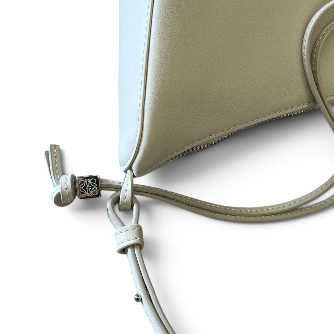 SWORD LUXURY Loewe Mini Hammock çanta, gümüş tonlu metal detaylı ve ayarlanabilir askılı krem rengi deri tasarım.