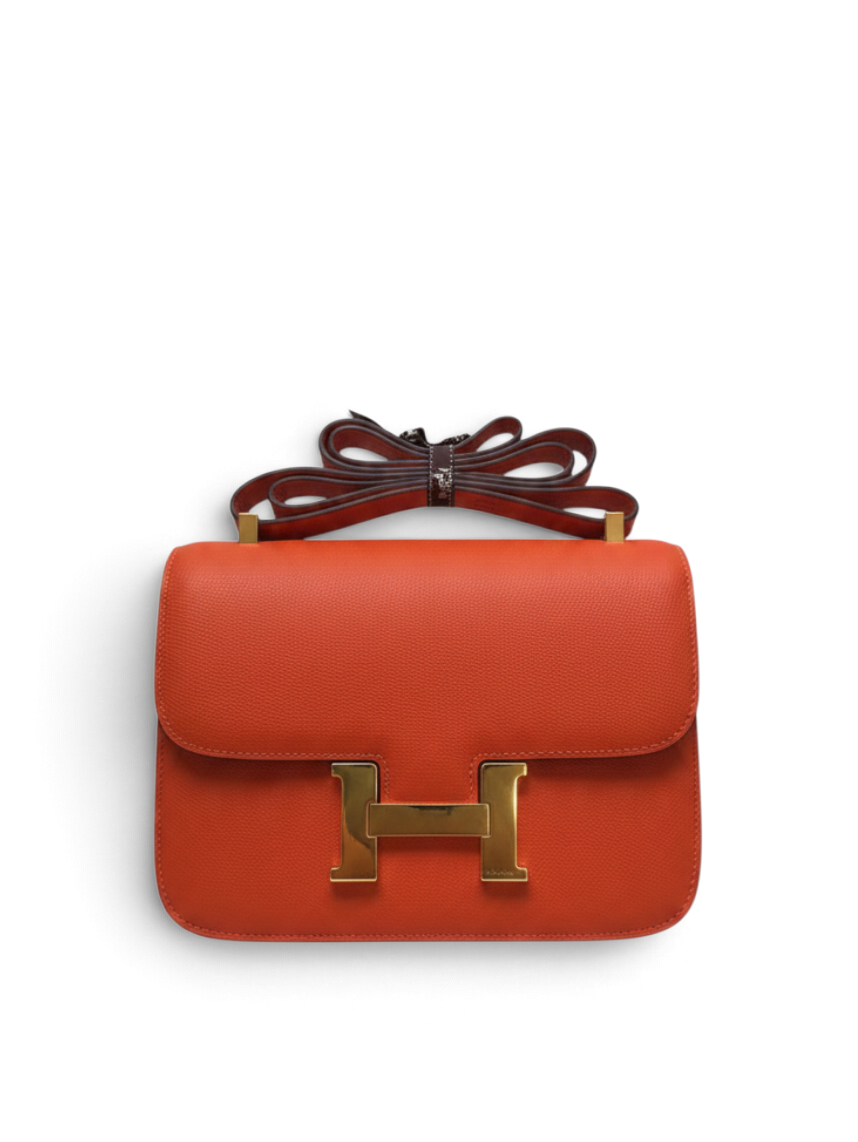 SWORD LUXURY imzalı, altın donanımlı H tokalı, turuncu Epsom deri Hermès Constance 18 omuz çantası.