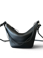 SWORD LUXURY imzalı, siyah deri, ayarlanabilir askılı ve ikonik düğümlü yan panellere sahip Loewe Mini Hammock çanta.
