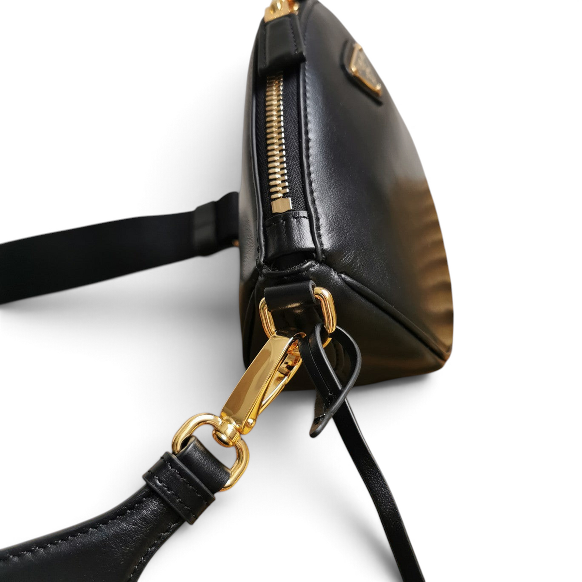 SWORD LUXURY Prada siyah deri mini omuz çantası, altın tonlu fermuar ve metal detaylı yan görünüm.