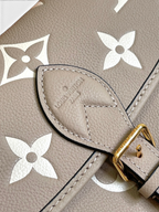 SWORD LUXURY Louis Vuitton Diane çanta, krem rengi Monogram Empreinte deri, altın tonlu toka ve kabartmalı detaylar.
