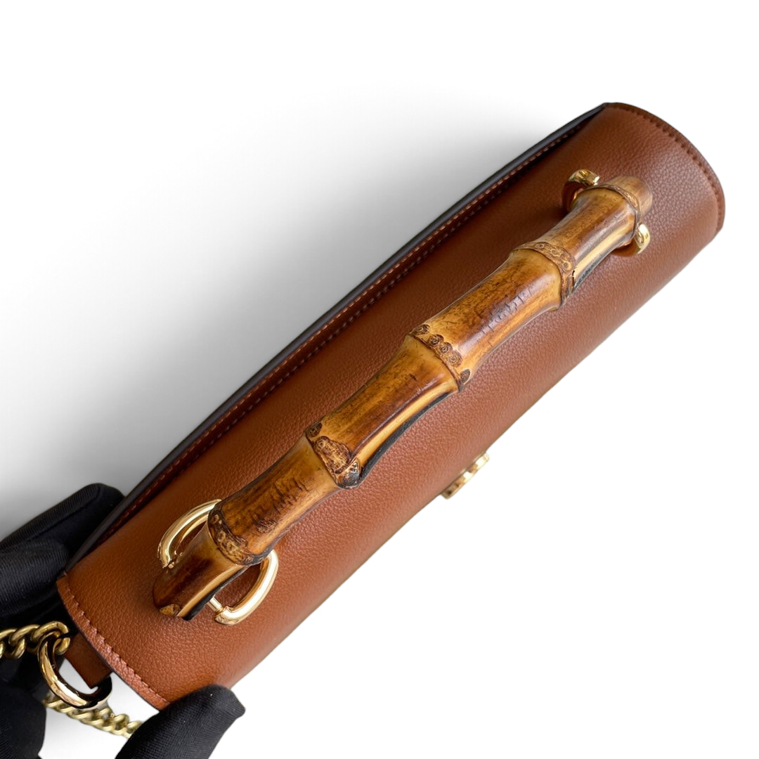 SWORD LUXURY marka, bambu saplı, kahverengi deri Gucci çanta, yeşil kutusu ve altın zincir detayı ile üstten görünüm.