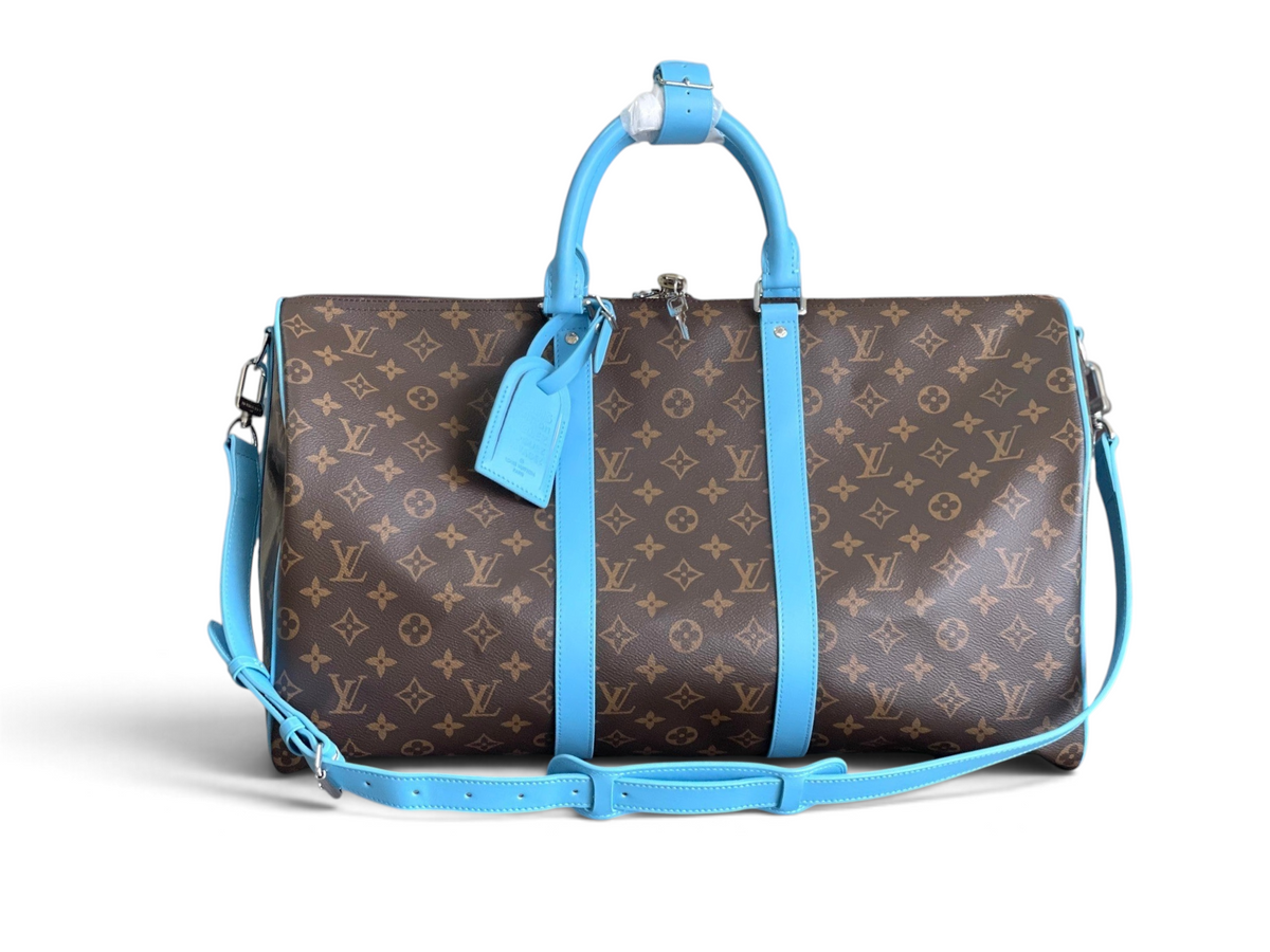 SWORD LUXURY Louis Vuitton Keepall Bandoulière 50, ikonik Monogram kanvas ve canlı gökyüzü mavisi deri detaylı seyahat çantası.