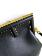 SWORD LUXURY Fendi First orta boy siyah deri çanta, altın rengi metal F detaylı çerçeve ve mıknatıslı kapama.