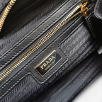 SWORD LUXURY Prada Re-Nylon ve Saffiano deri çanta iç detayı, altın tonlu fermuar ve marka logolu astar.