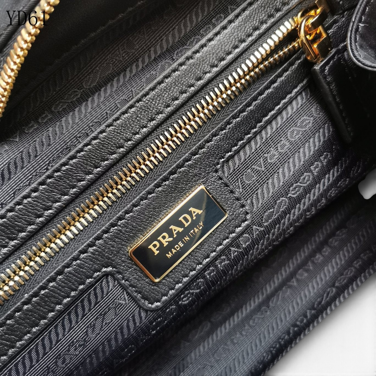 SWORD LUXURY Prada Re-Nylon ve Saffiano deri çanta iç detayı, altın tonlu fermuar ve marka logolu astar.