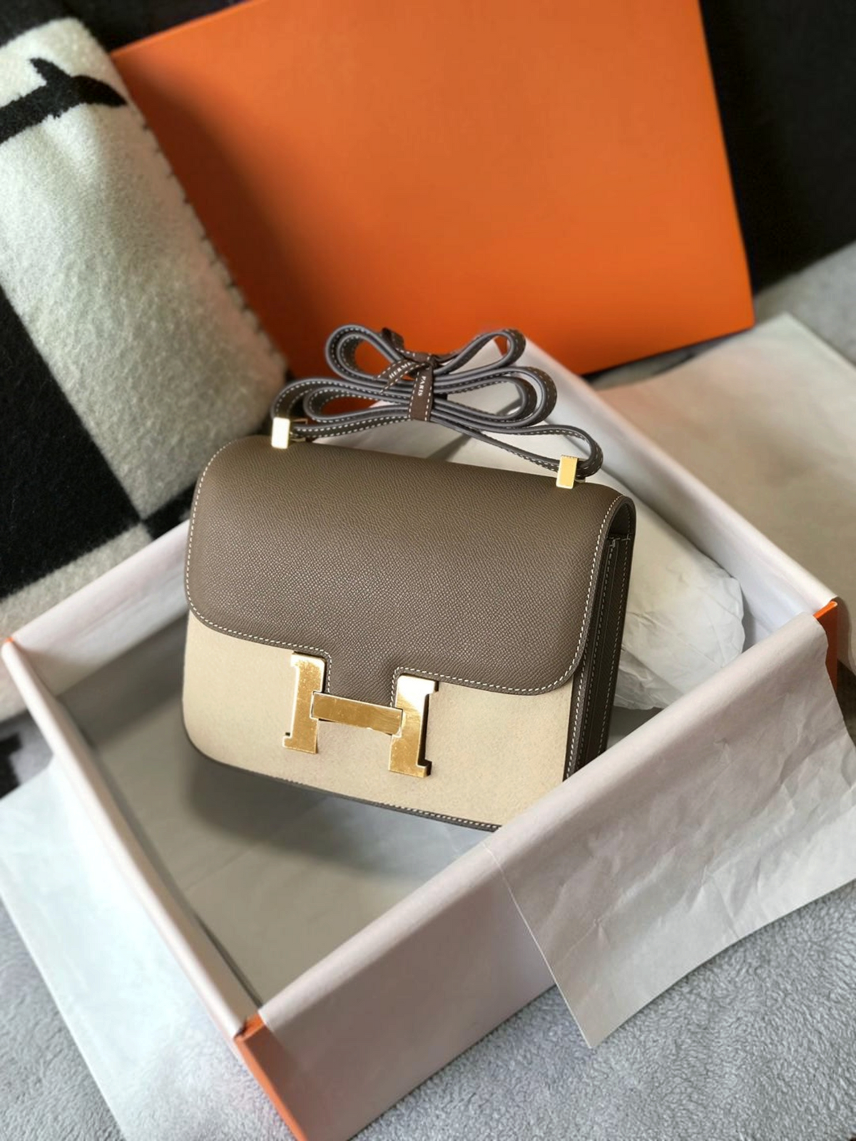 SWORD LUXURY Hermès Constance 23 çanta, taupe deri ve bej süet detaylı, altın renkli H tokalı, kutusunda.