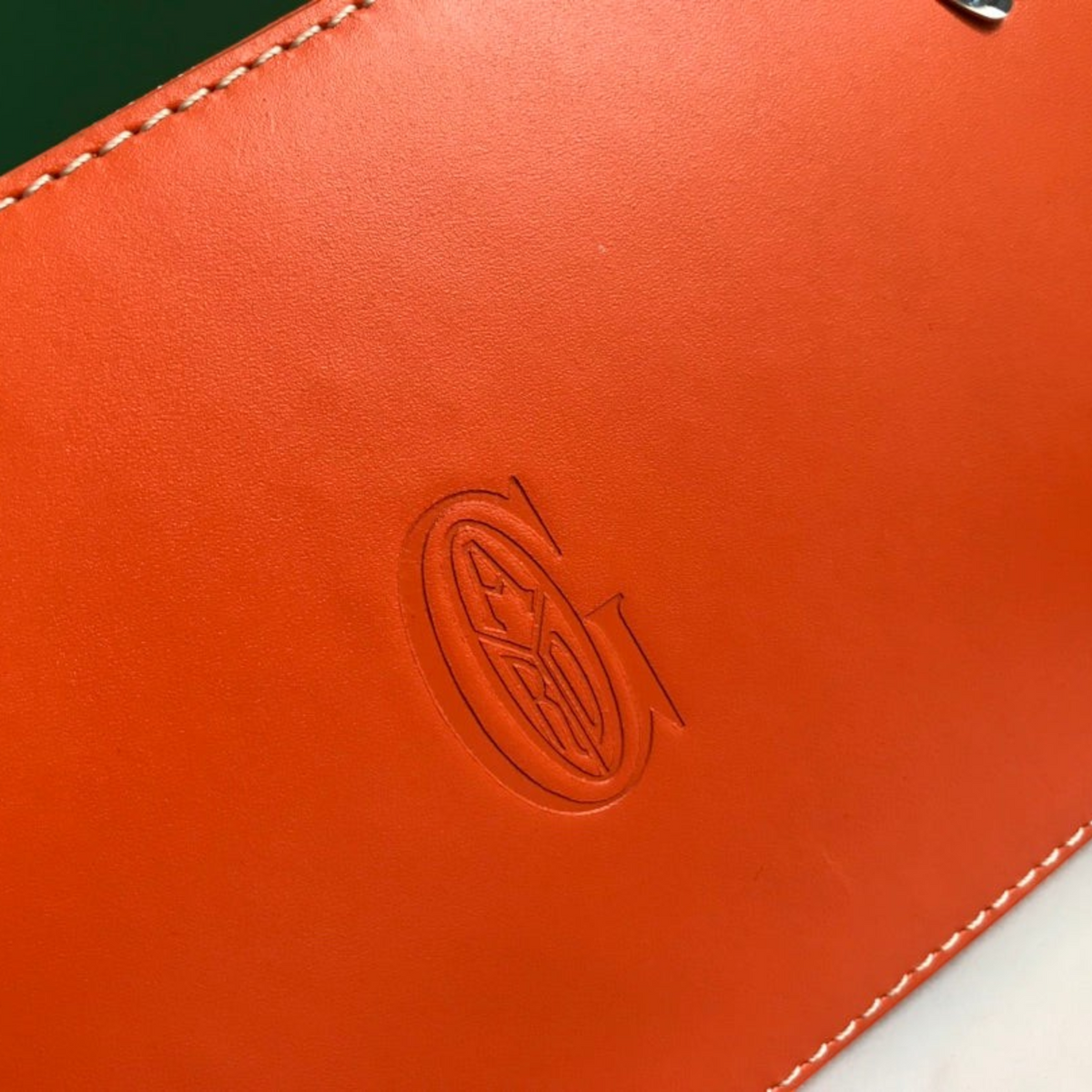 SWORD LUXURY Saïgon PM handbag featuring vibrant orange smooth leather with a debossed logo and white contrast stitching
