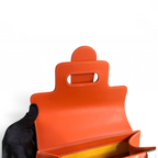 SWORD LUXURY Saïgon PM handbag featuring a vibrant orange leather flap with white stitching and a yellow interior.