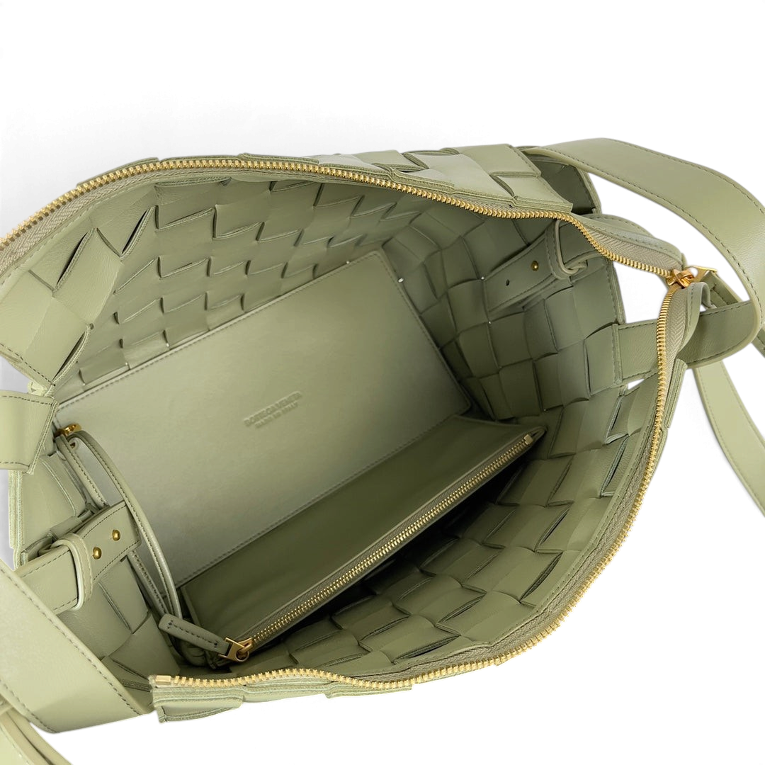 SWORD LUXURY Bottega Veneta Small Cassette Bowling Bag'in içi, yeşil Intrecciato örgülü deri ve fermuarlı bölme detayı.