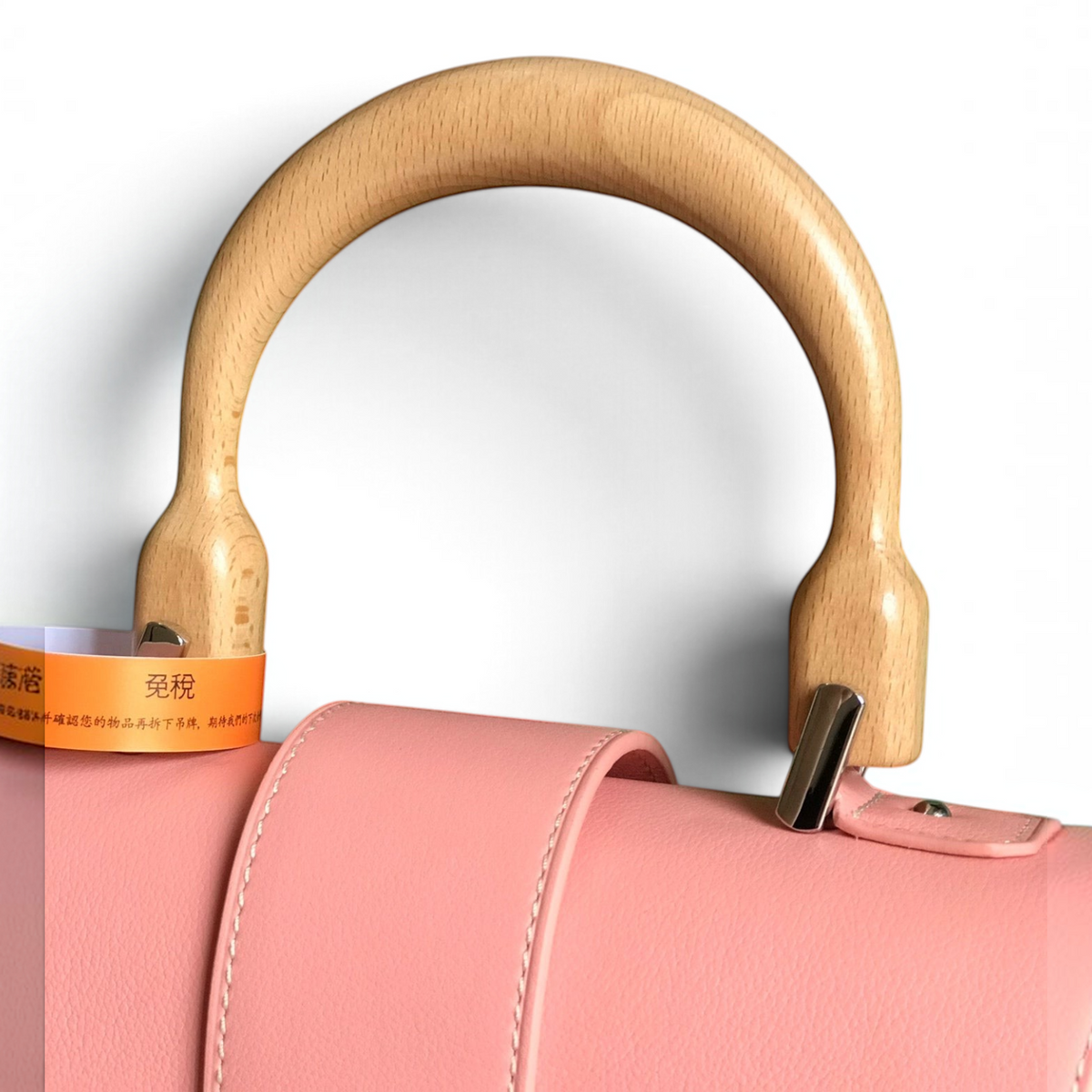 SWORD LUXURY Saïgon PM handbag featuring a smooth pink leather flap and a distinctive curved beechwood top handle.