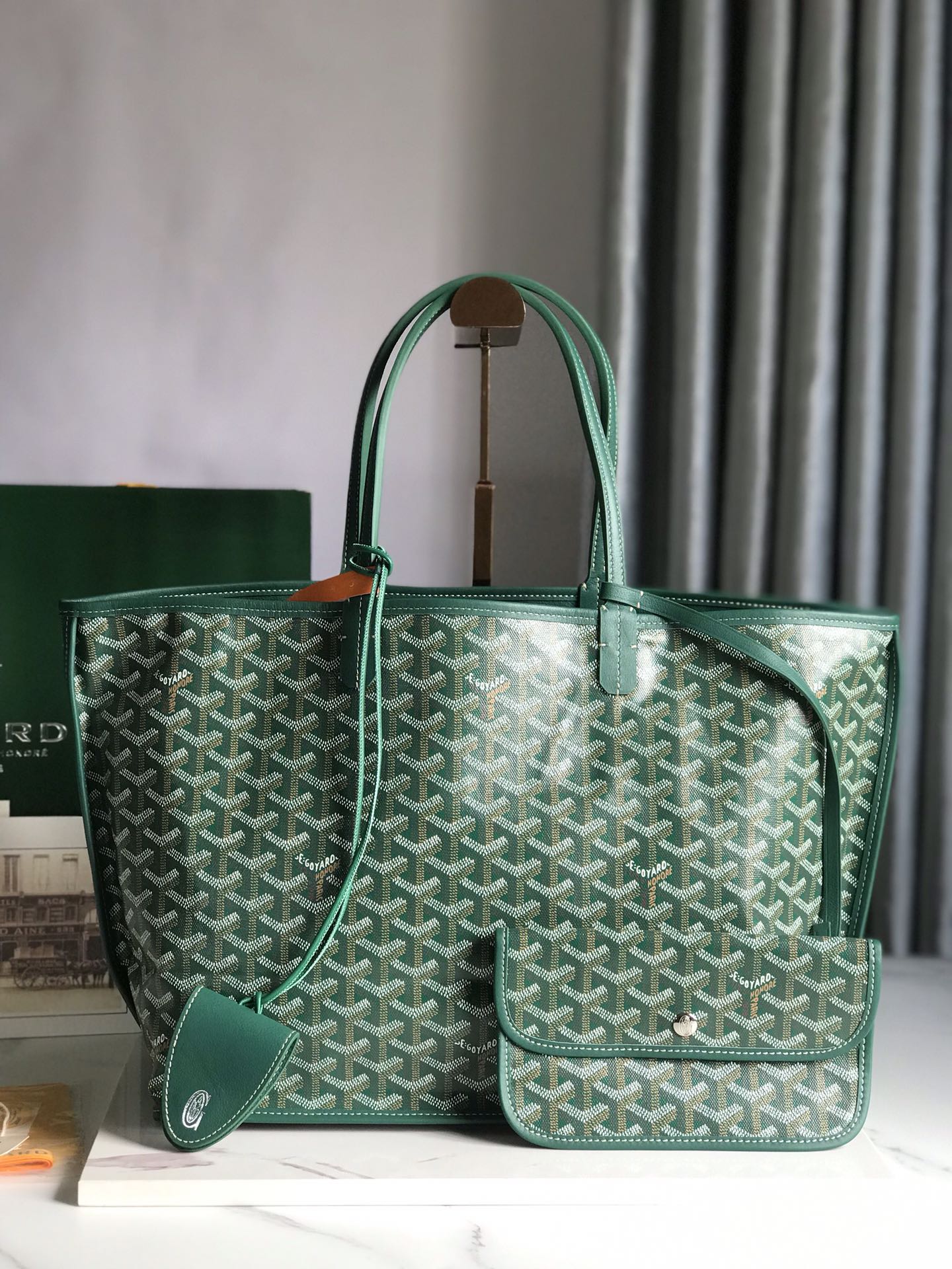 Green patterned handbag on a white surface with a blurred background