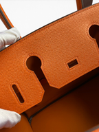 SWORD LUXURY turuncu Epsom deri Hermès Birkin 30 çanta detayı, dokulu deri yüzeyi ve hassas dikişleri gösteriyor.