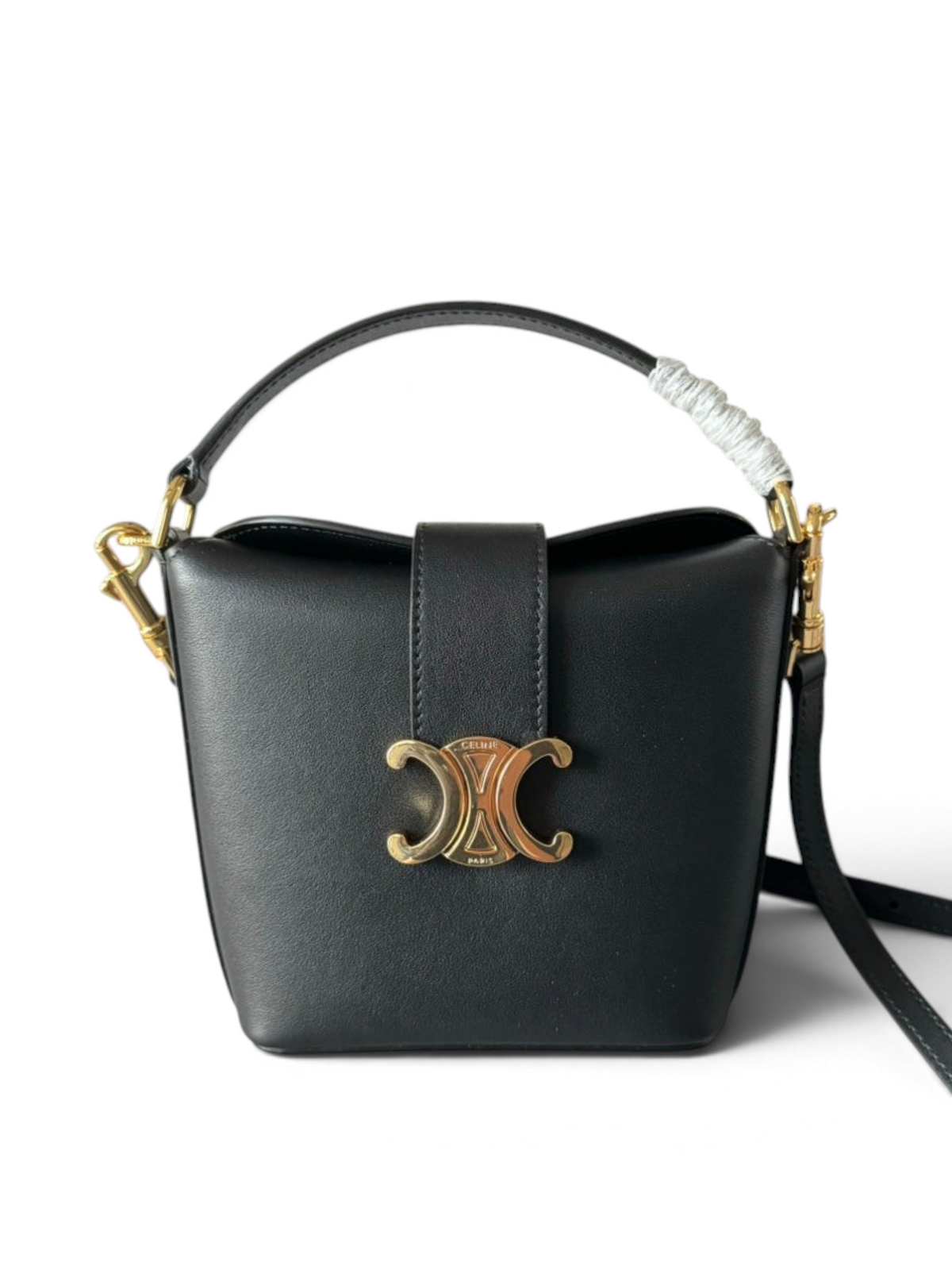 SWORD LUXURY siyah deri mini kova çanta, altın rengi Triomphe amblemi ve çıkarılabilir omuz askısı ile.