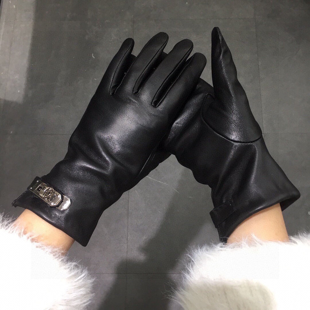 Black leather gloves held up against a dark background