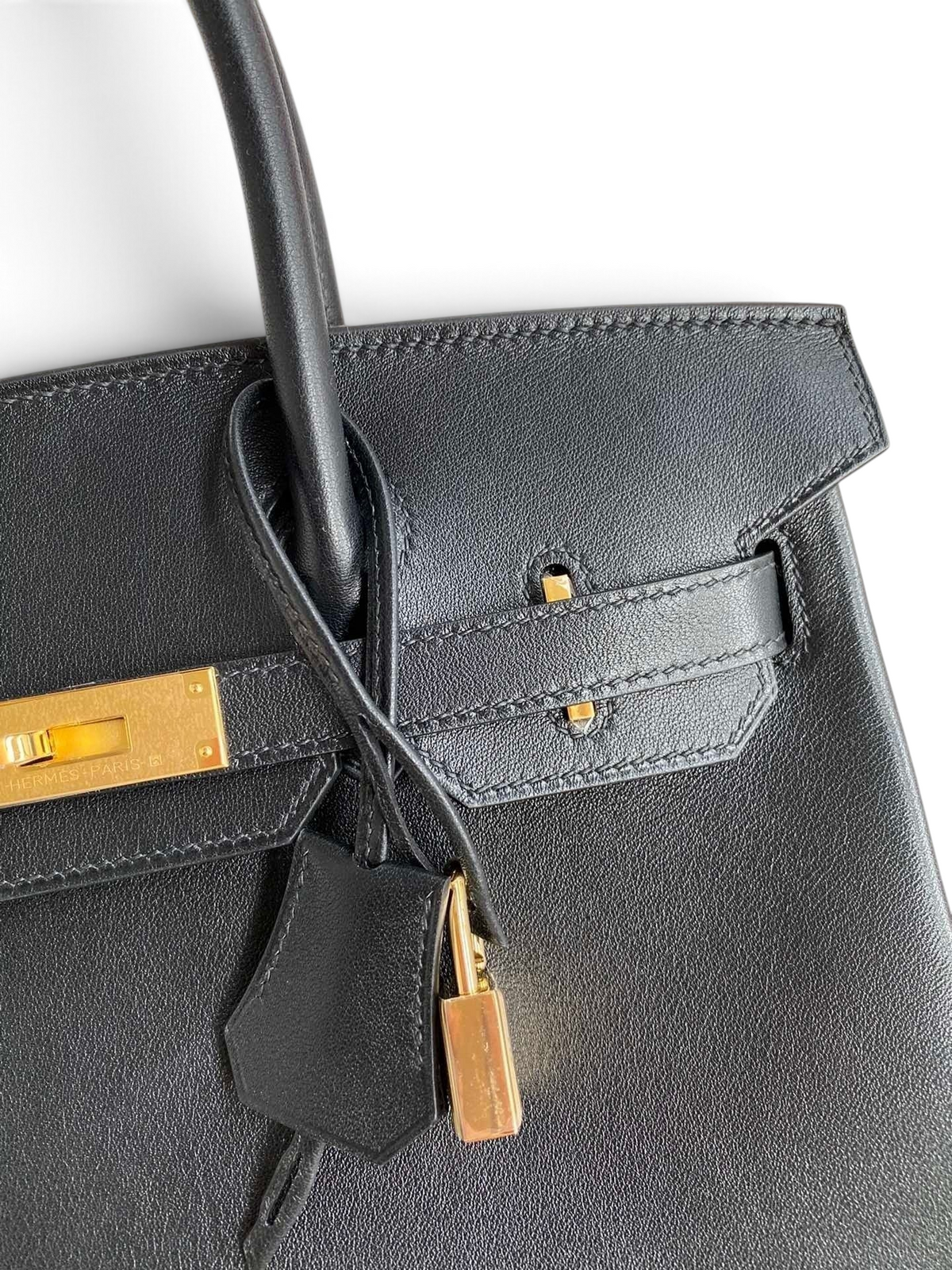 SWORD LUXURY imzalı, altın donanımlı ve kilit detaylı siyah Swift dana derisi Hermès Birkin 25cm çanta.