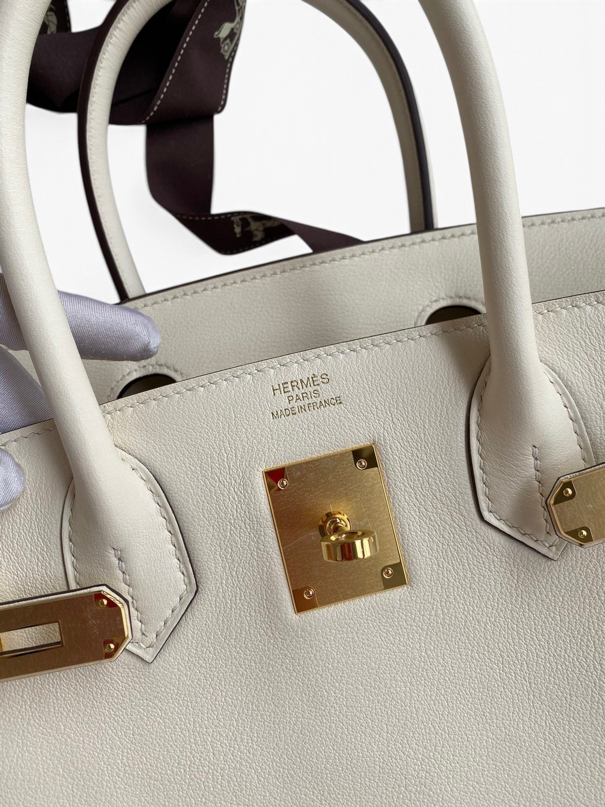 SWORD LUXURY imzalı, altın donanımlı, beyaz Swift dana derisi Hermès Birkin 25cm çanta detayı.