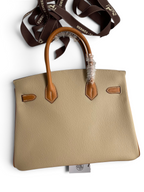 SWORD LUXURY marka, iki tonlu bej ve taba renkli, Epsom deri Hermès Birkin 25cm çanta, kutu içinde.