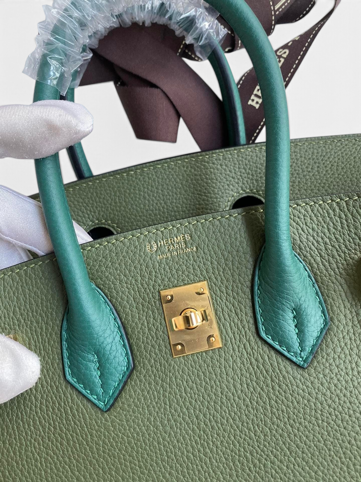 SWORD LUXURY marka, yeşil Togo deri Hermès Birkin 25cm çanta, altın rengi donanım ve ikonik kilit detayı ile.