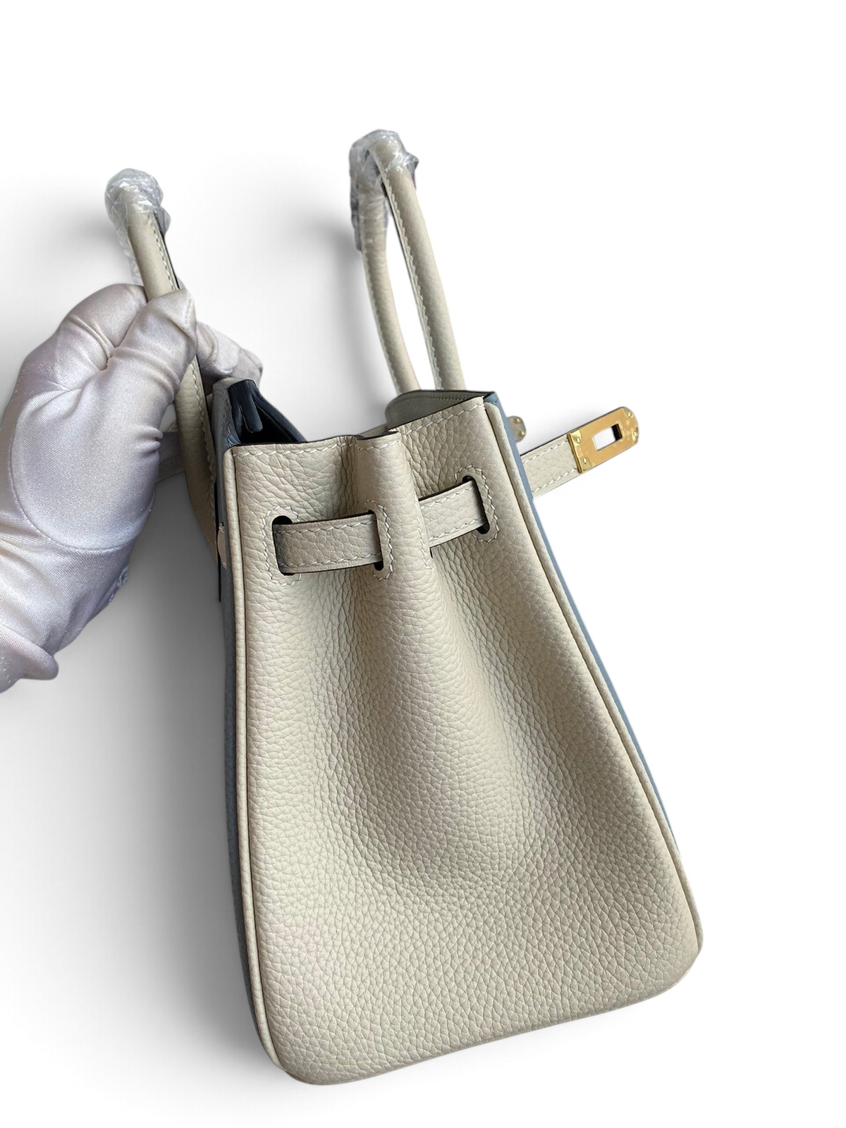 SWORD LUXURY marka, bej renkli, dokulu Togo deri Hermès Birkin 25cm çanta, kutusunda ve koruyucu eldivenli elle tutuluyor.