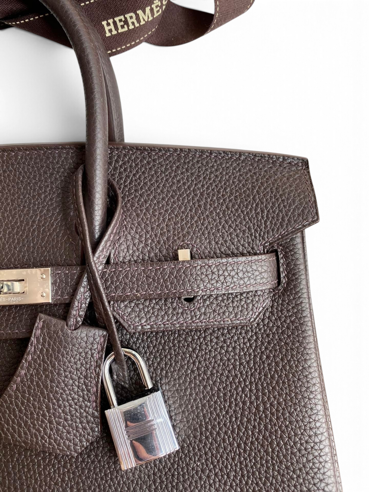SWORD LUXURY marka, koyu kahverengi Togo deri Hermès Birkin 25cm çanta, gümüş donanım ve ikonik kilit detayı ile.