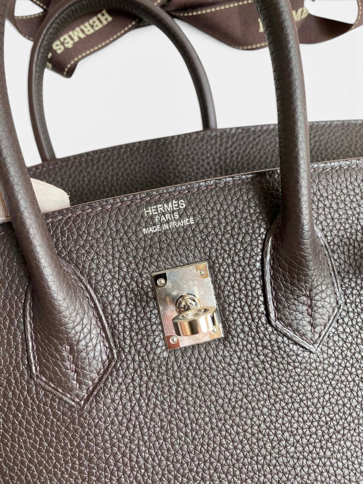 SWORD LUXURY Hermès Birkin 25cm çanta, kahverengi Togo deri dokusu ve gümüş renkli metal detayları ile yakından görünüm.