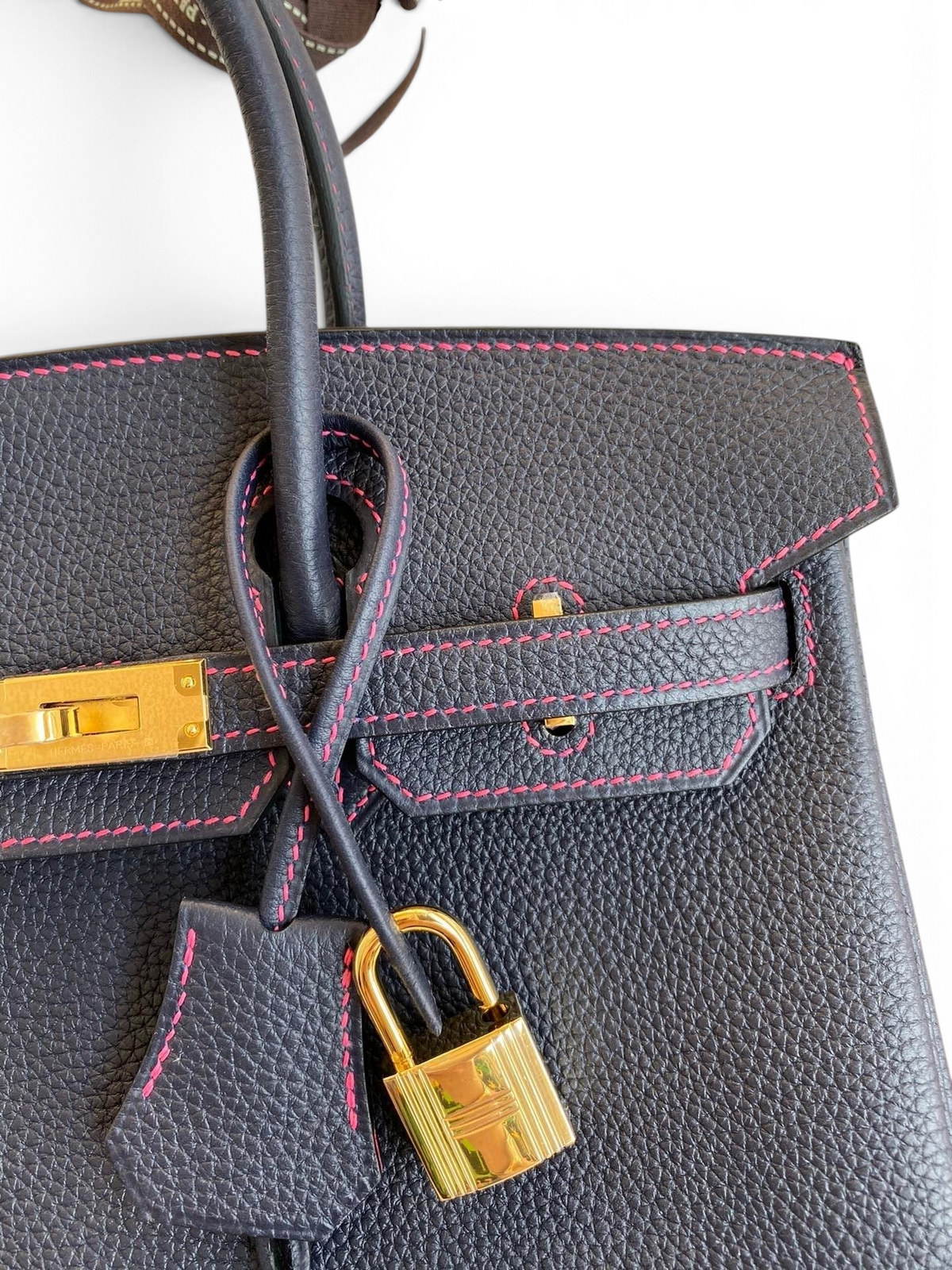 SWORD LUXURY marka, pembe dikiş detaylı, altın donanımlı ve kilitli siyah Togo deri Hermès Birkin 25cm çanta.