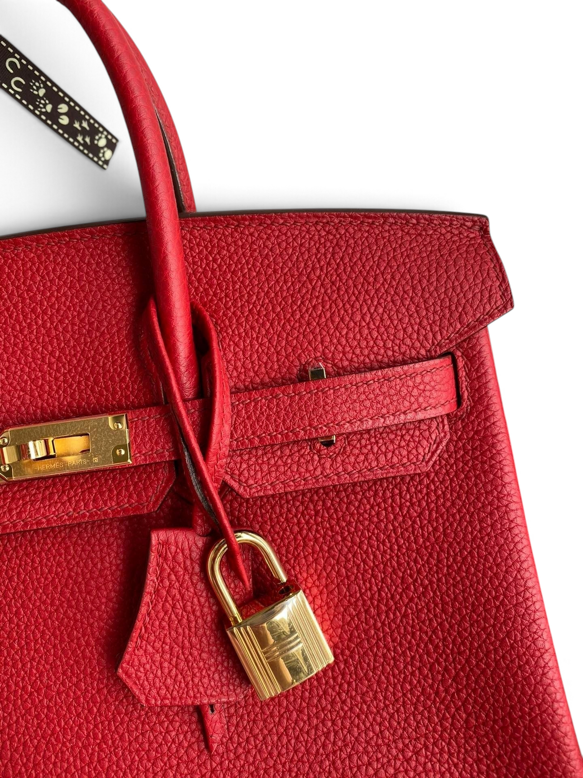 SWORD LUXURY marka, kırmızı Togo deri Hermès Birkin 25cm çanta, altın rengi kilit ve detaylı dokulu deri yüzey.