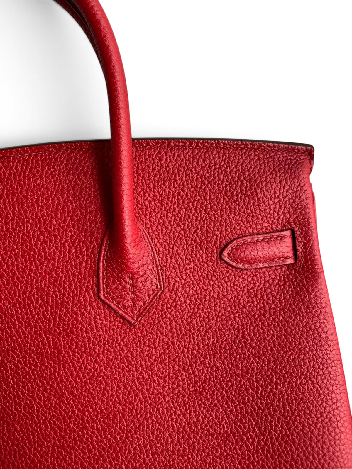 SWORD LUXURY imzalı, kırmızı Togo deri dokusuna ve zarif dikiş detaylarına sahip 25 cm Hermès Birkin çanta detayı.