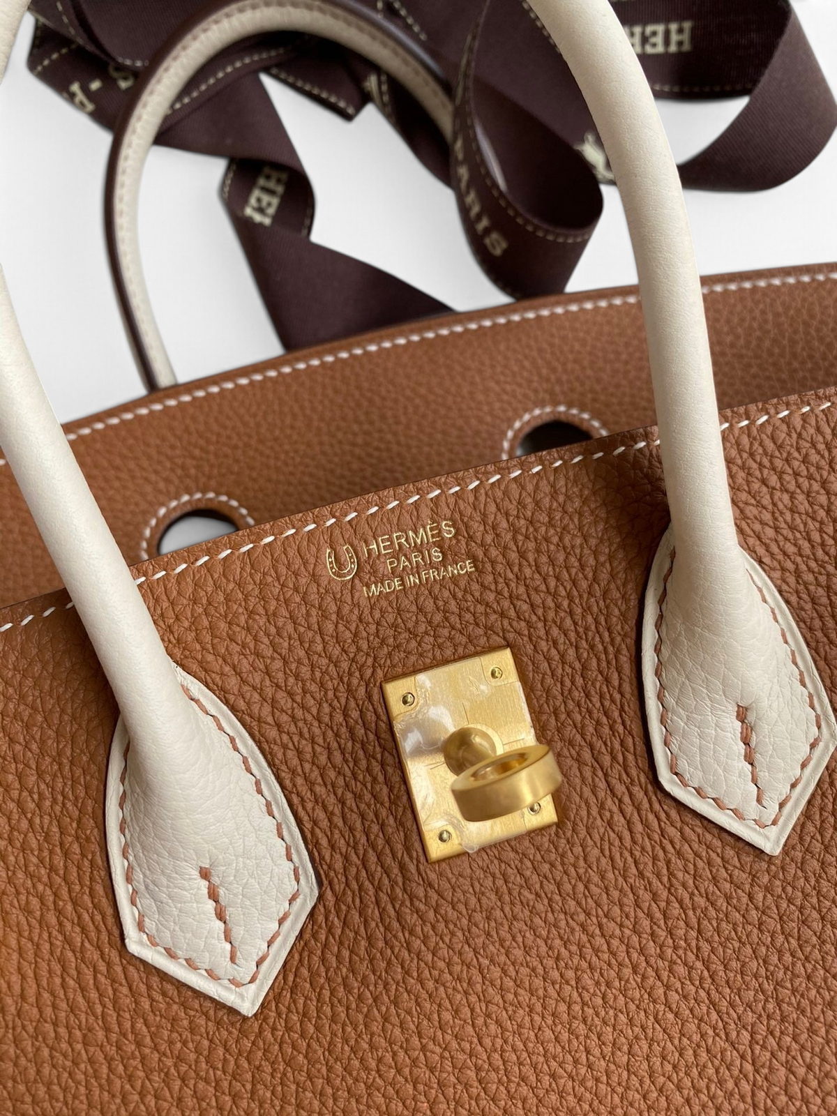 SWORD LUXURY Hermès Birkin 25cm çanta, taba rengi Togo deri, beyaz deri detaylar ve altın rengi metal donanım.