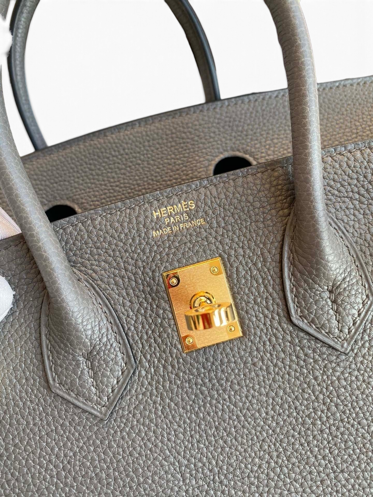 SWORD LUXURY gri Togo deri Hermès Birkin 25 cm çanta, altın rengi metal detaylı ve ikonik marka damgalı ön yüzü.