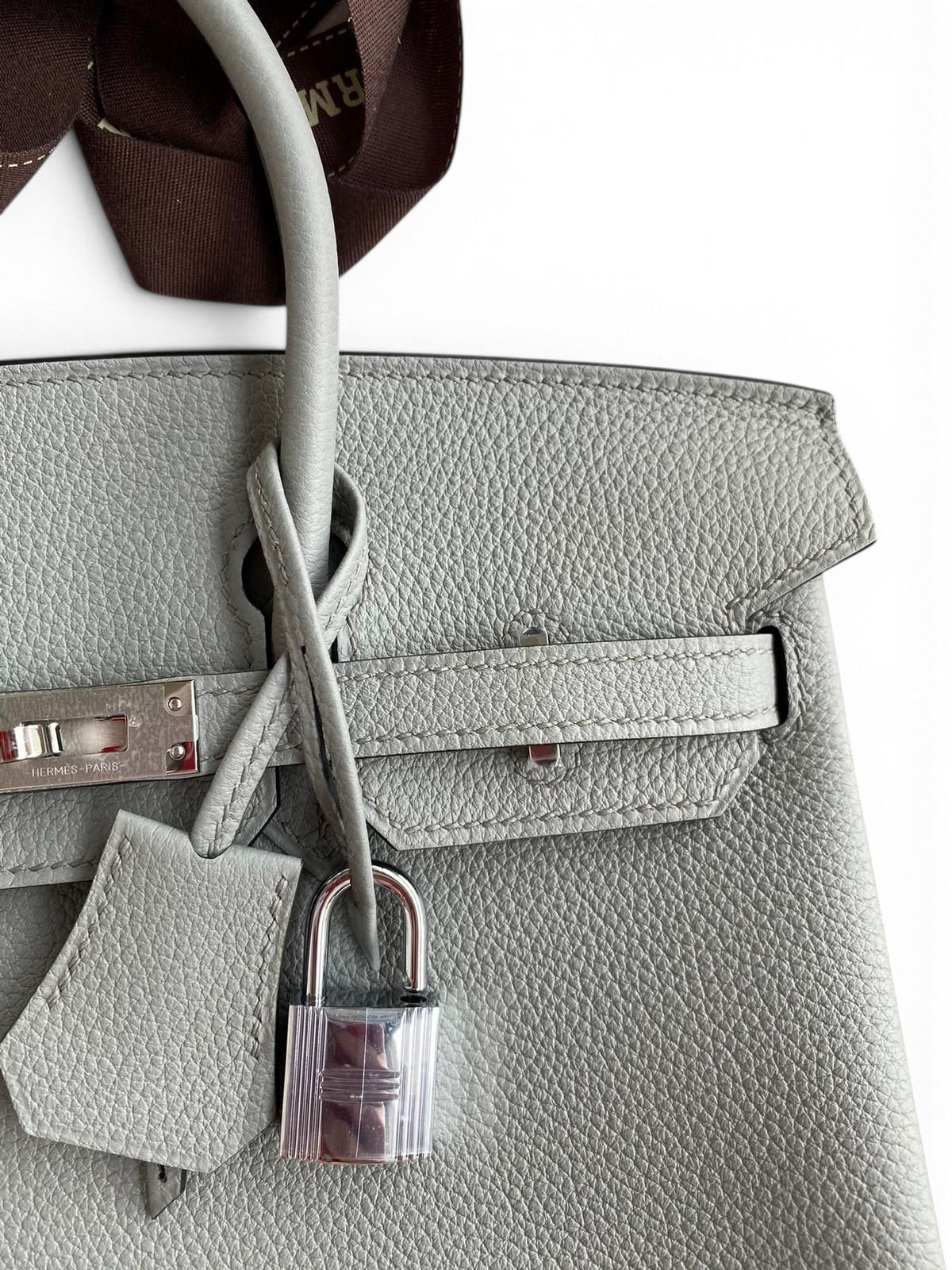 SWORD LUXURY marka gri Togo deri Hermès Birkin 25cm çanta, gümüş donanım ve ikonik kilit detaylı yakın çekim.