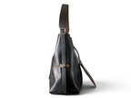 SWORD LUXURY CarryAll siyah kuzu derisi omuz çantası, yan profil görünümü, monogram detaylı askı ve gümüş donanım.
