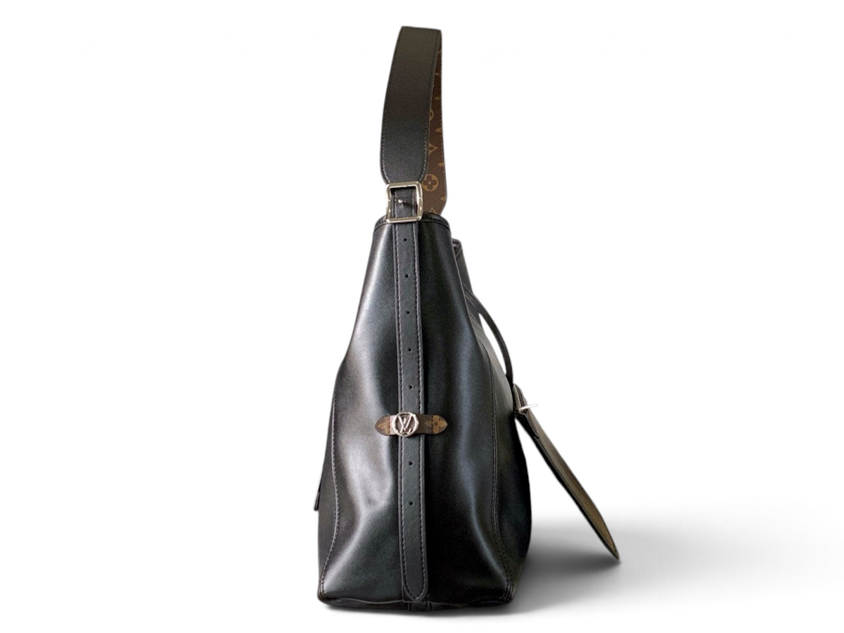 SWORD LUXURY CarryAll siyah kuzu derisi omuz çantası, yan profil görünümü, monogram detaylı askı ve gümüş donanım.