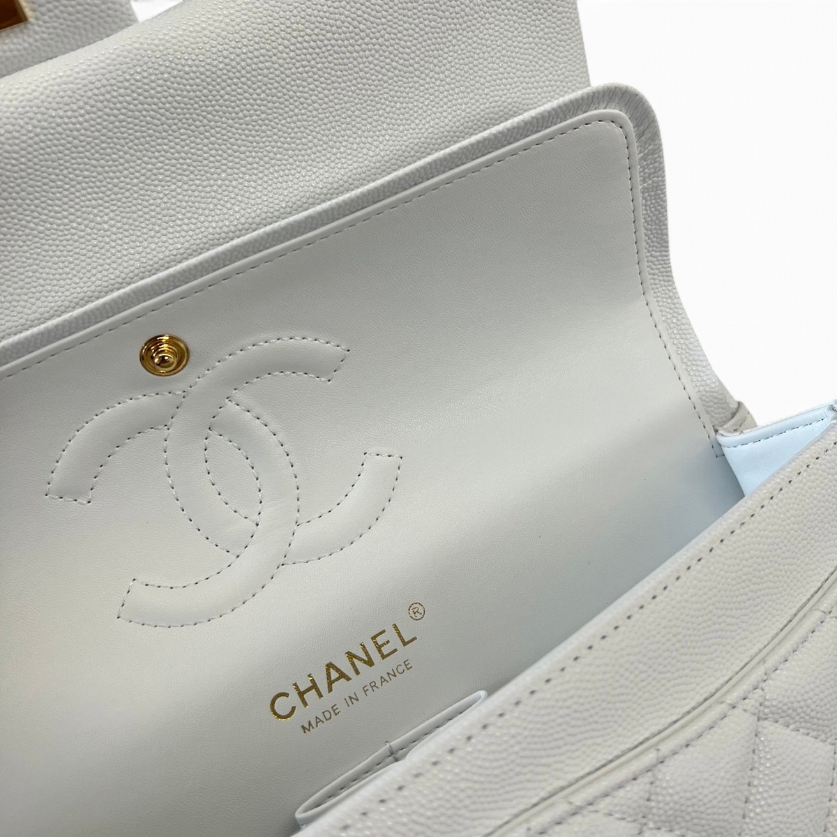 SWORD LUXURY Chanel beyaz caviar deri kapitone çanta iç detayı, altın rengi CC logosu ve Made in France damgası.