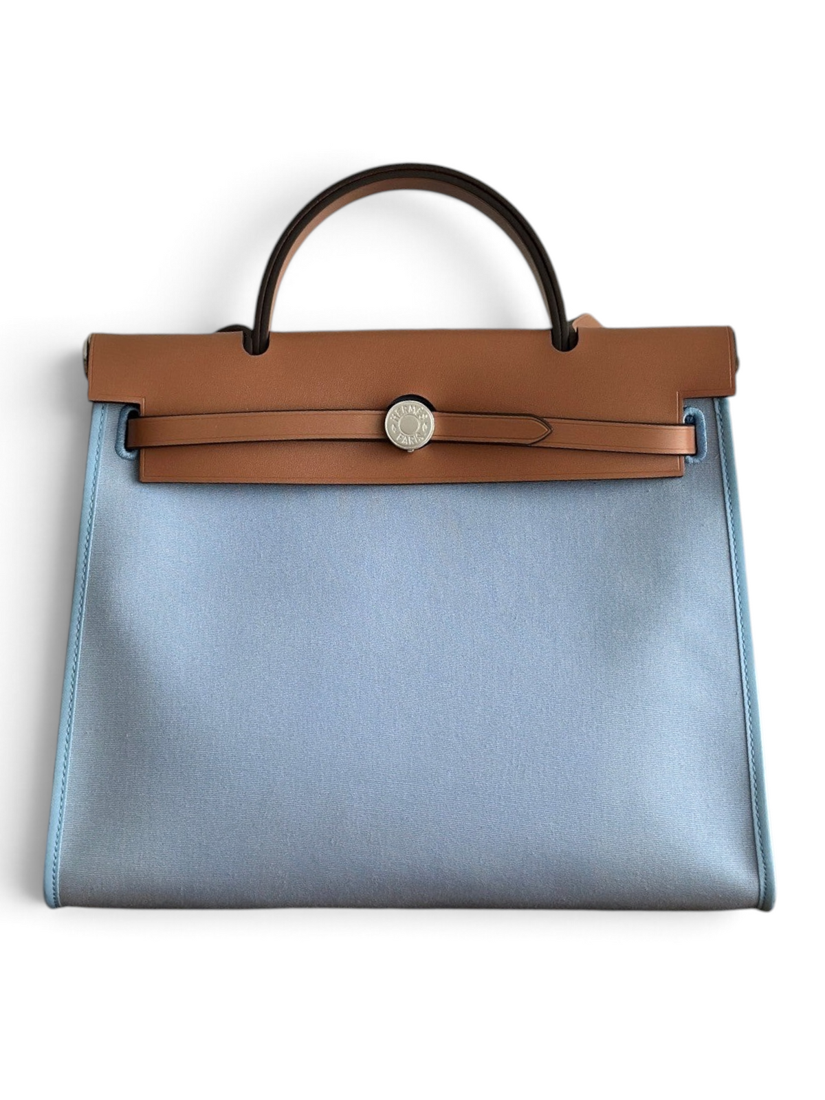 SWORD LUXURY Herbag 31 çanta, açık mavi kanvas gövde ve taba rengi deri kapak detaylı, şık ve modern tasarım.