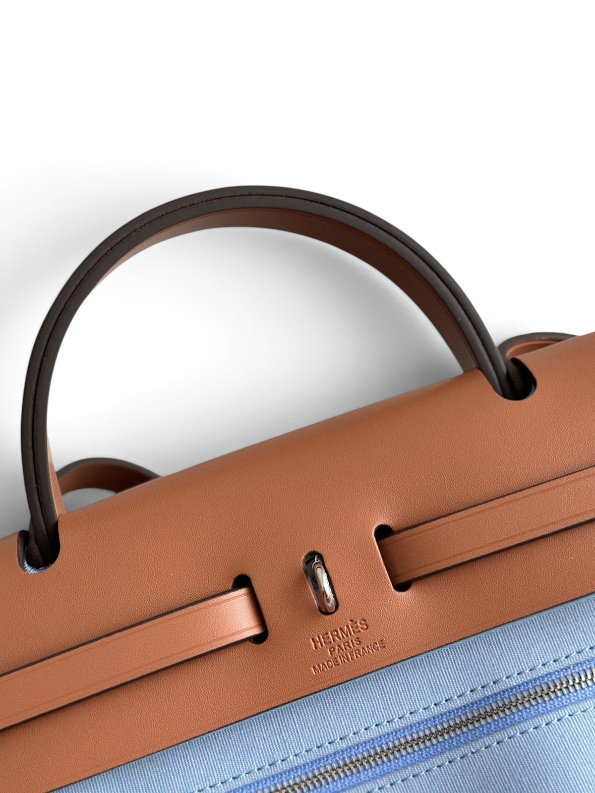 SWORD LUXURY Hermès Herbag 31 çanta, taba rengi deri kapaklı ve mavi kanvas gövdeli, Clou de Selle detaylı.