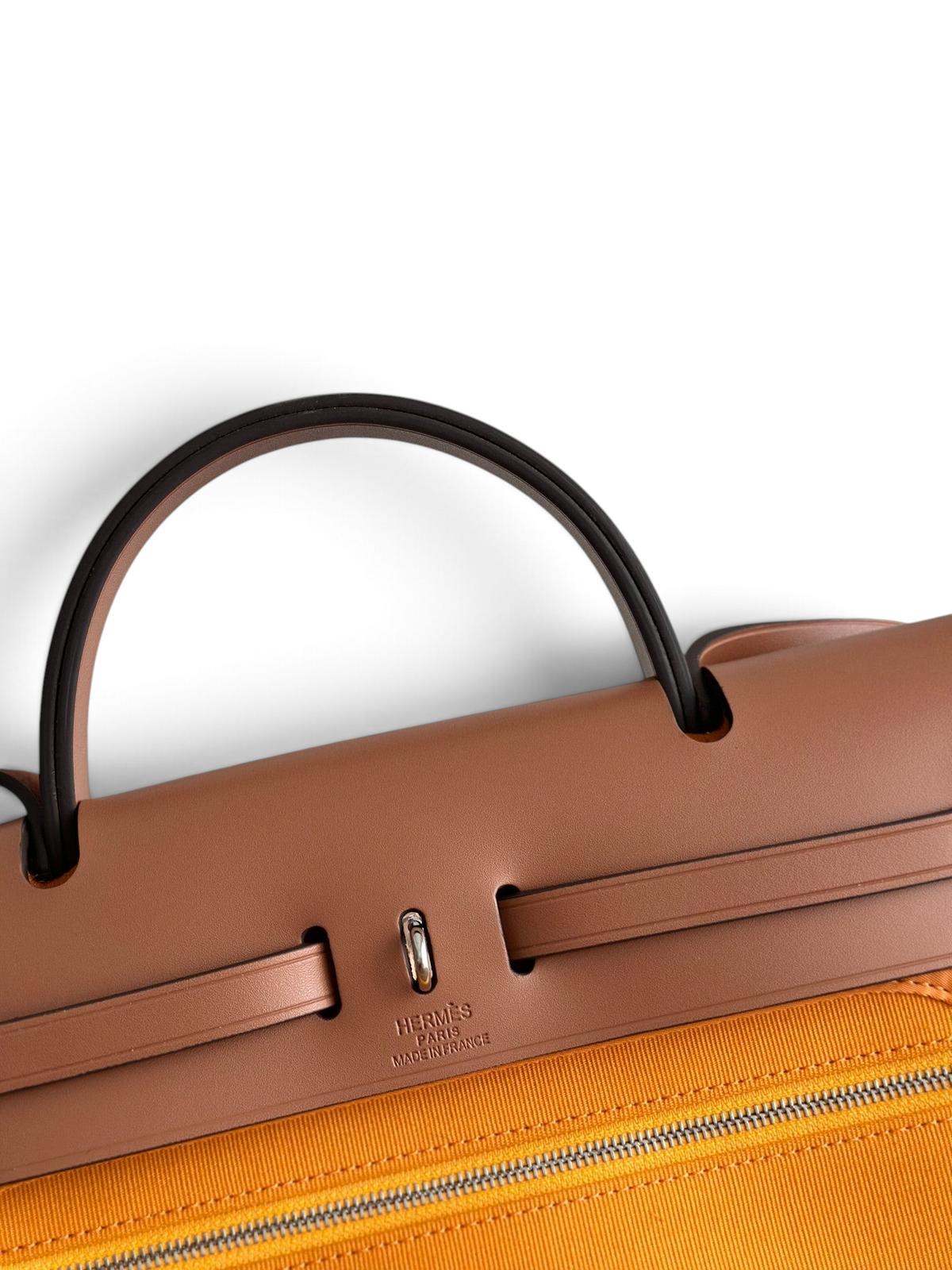 SWORD LUXURY Hermès Herbag 31 çanta, taba rengi deri kapak ve canlı turuncu kanvas gövde detaylarıyla.