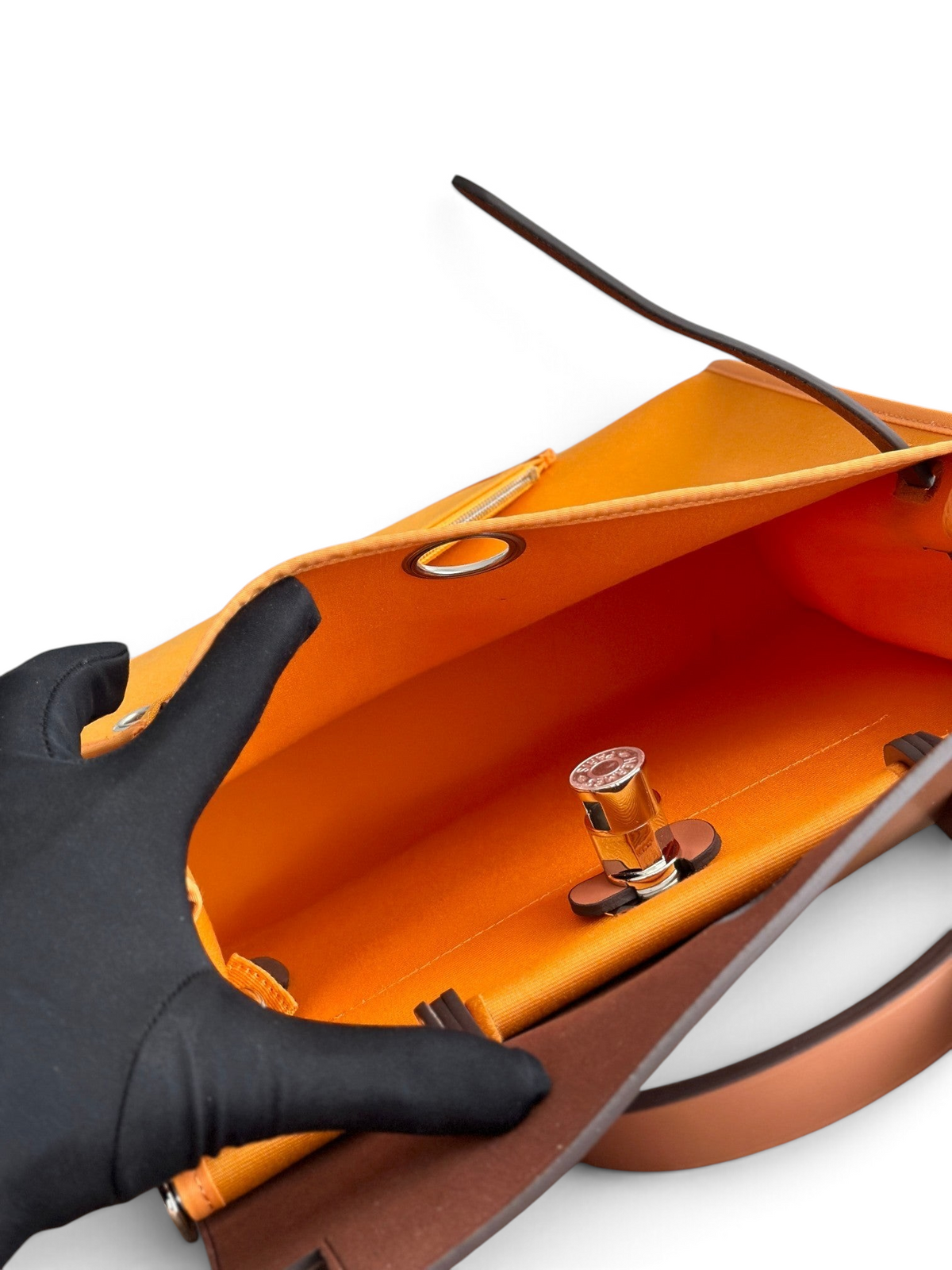 SWORD LUXURY Hermès Herbag 31 çanta, turuncu kanvas iç kısmı ve metalik Clou de Selle kilidi ile detaylandırılmış.