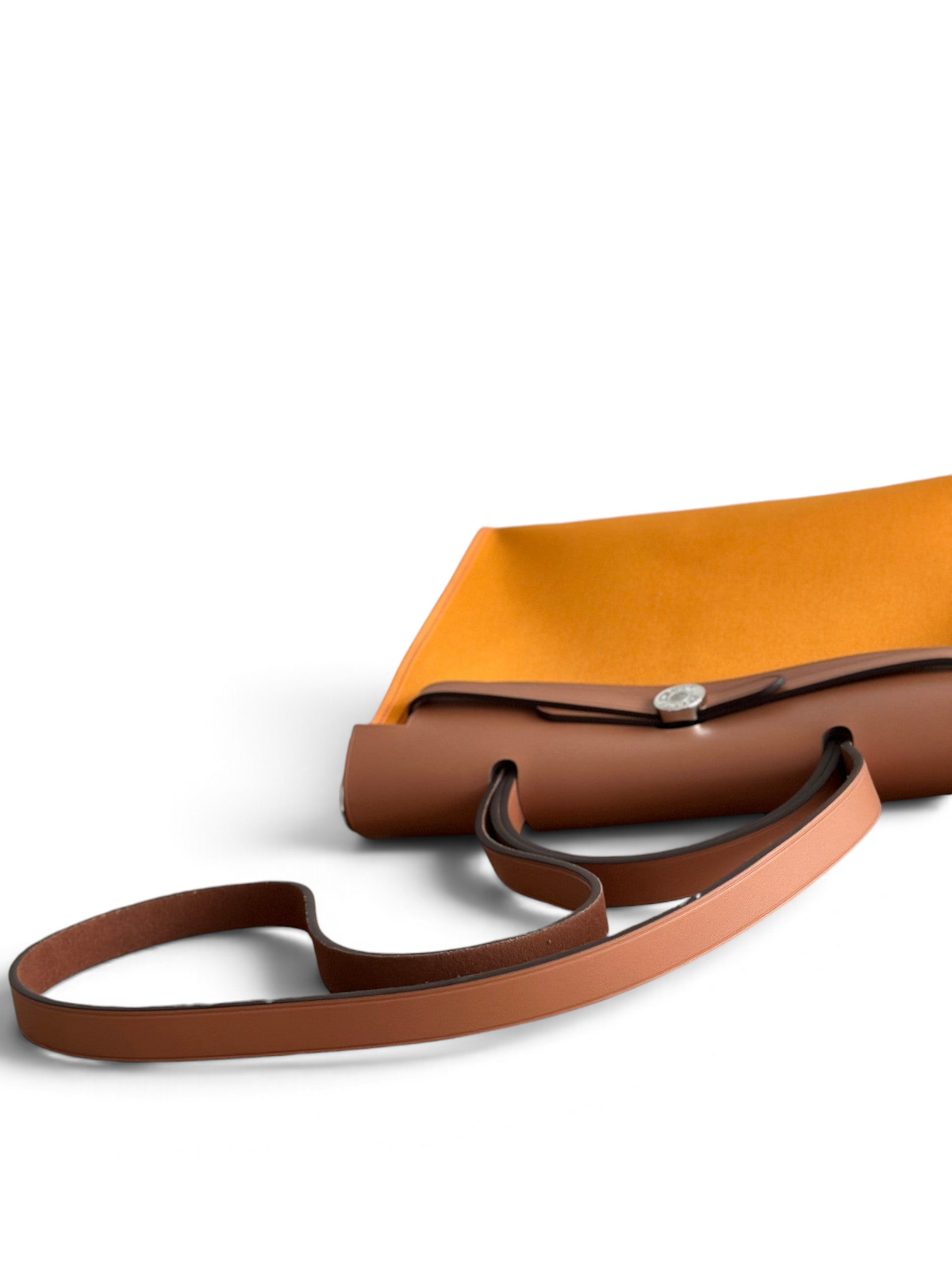 SWORD LUXURY Herbag 31 çanta, turuncu kanvas gövde ve kahverengi deri kapak detaylarıyla şık bir tasarım sunuyor.