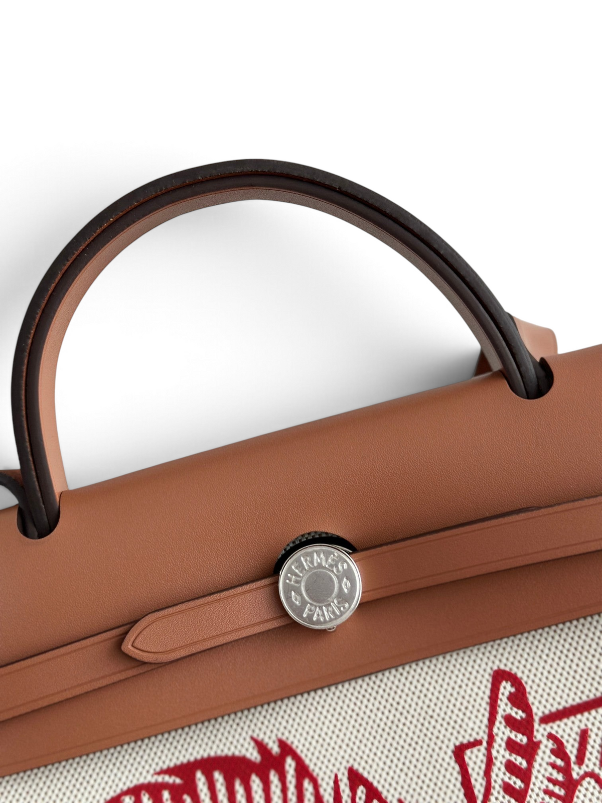 SWORD LUXURY Hermès Herbag 31 çanta, kahverengi deri kapaklı, Clou de Selle kilit detaylı ve sanatsal baskılı kanvas gövdeli.