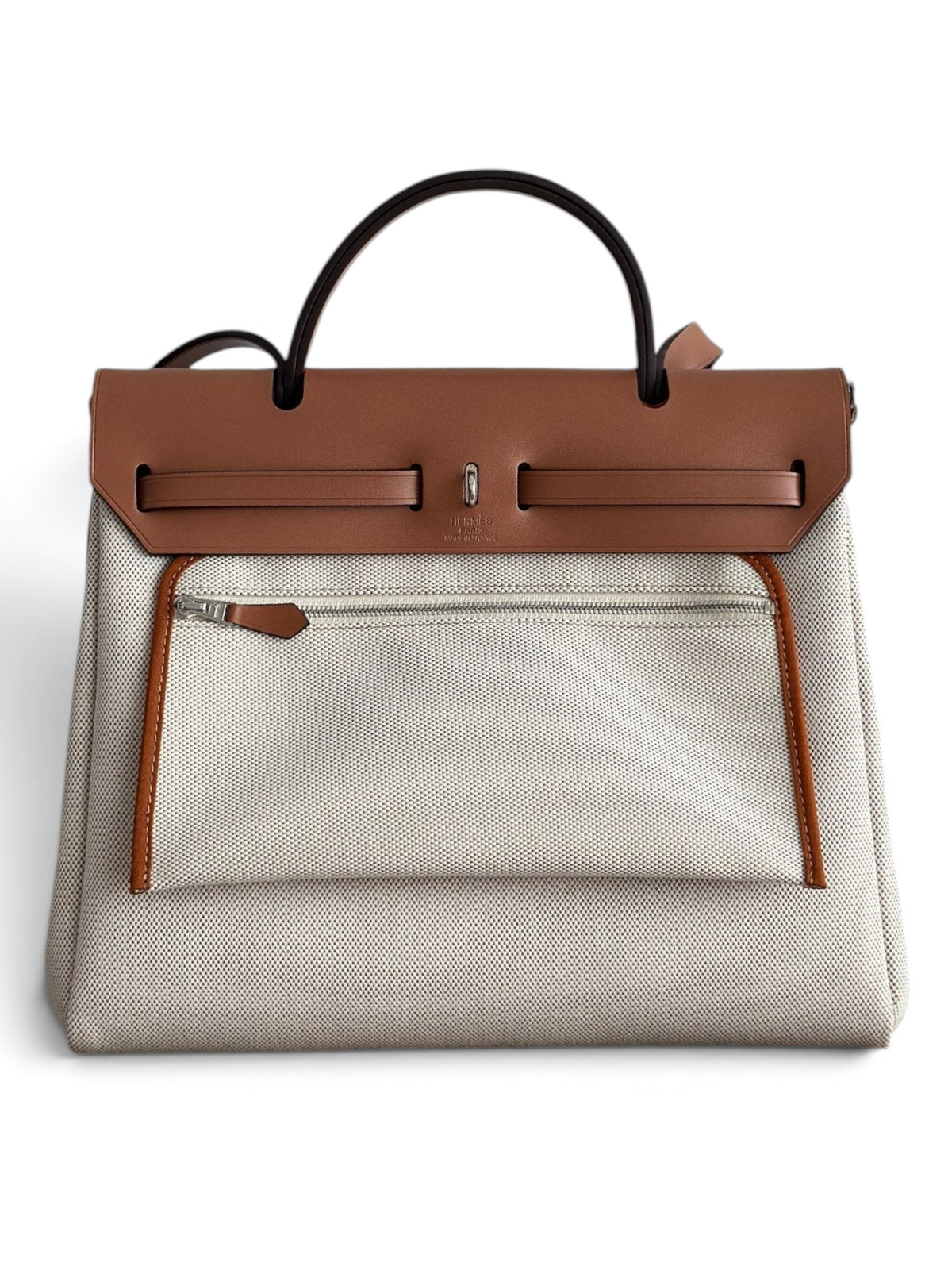 SWORD LUXURY Hermès Herbag 31 çanta, bej kanvas gövde, kahverengi deri kapak ve Clou de Selle detaylı şık tasarım.