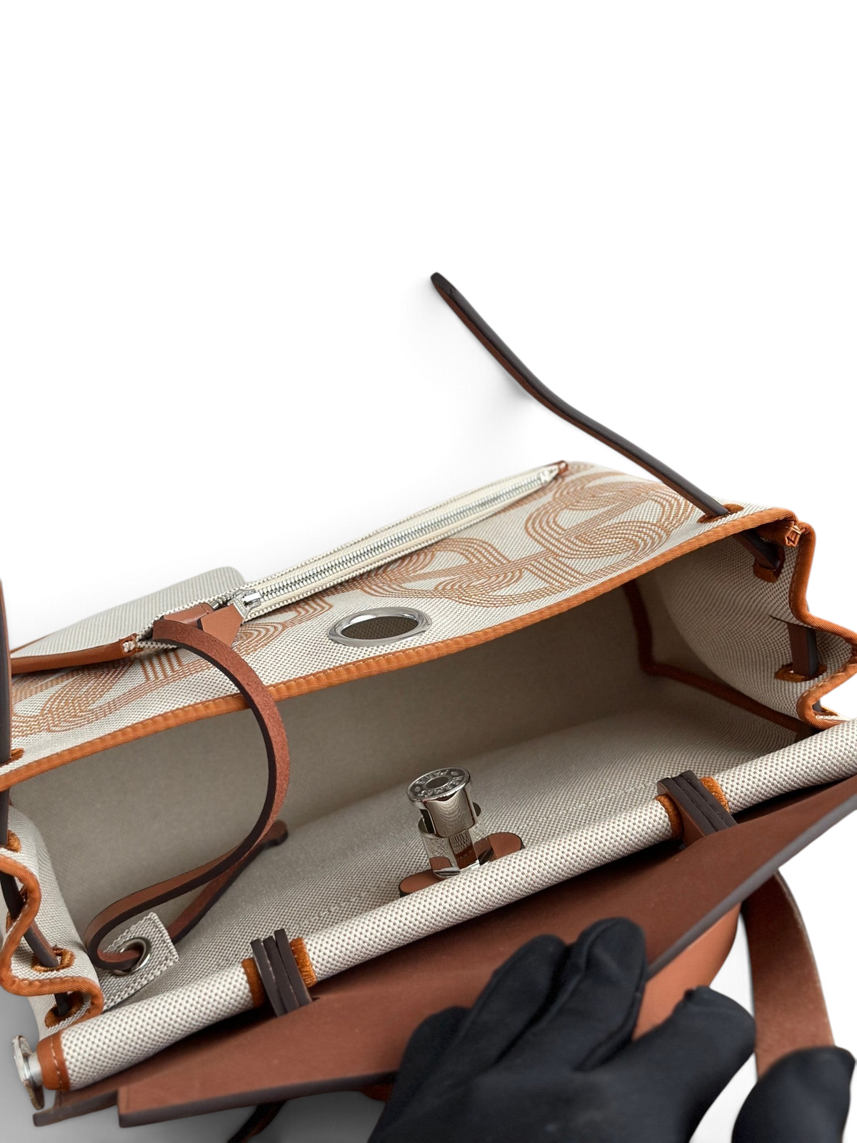 SWORD LUXURY Hermès Herbag 31 çanta, bej kanvas gövde, taba deri detaylar ve metalik Clou de Selle kilit mekanizması.