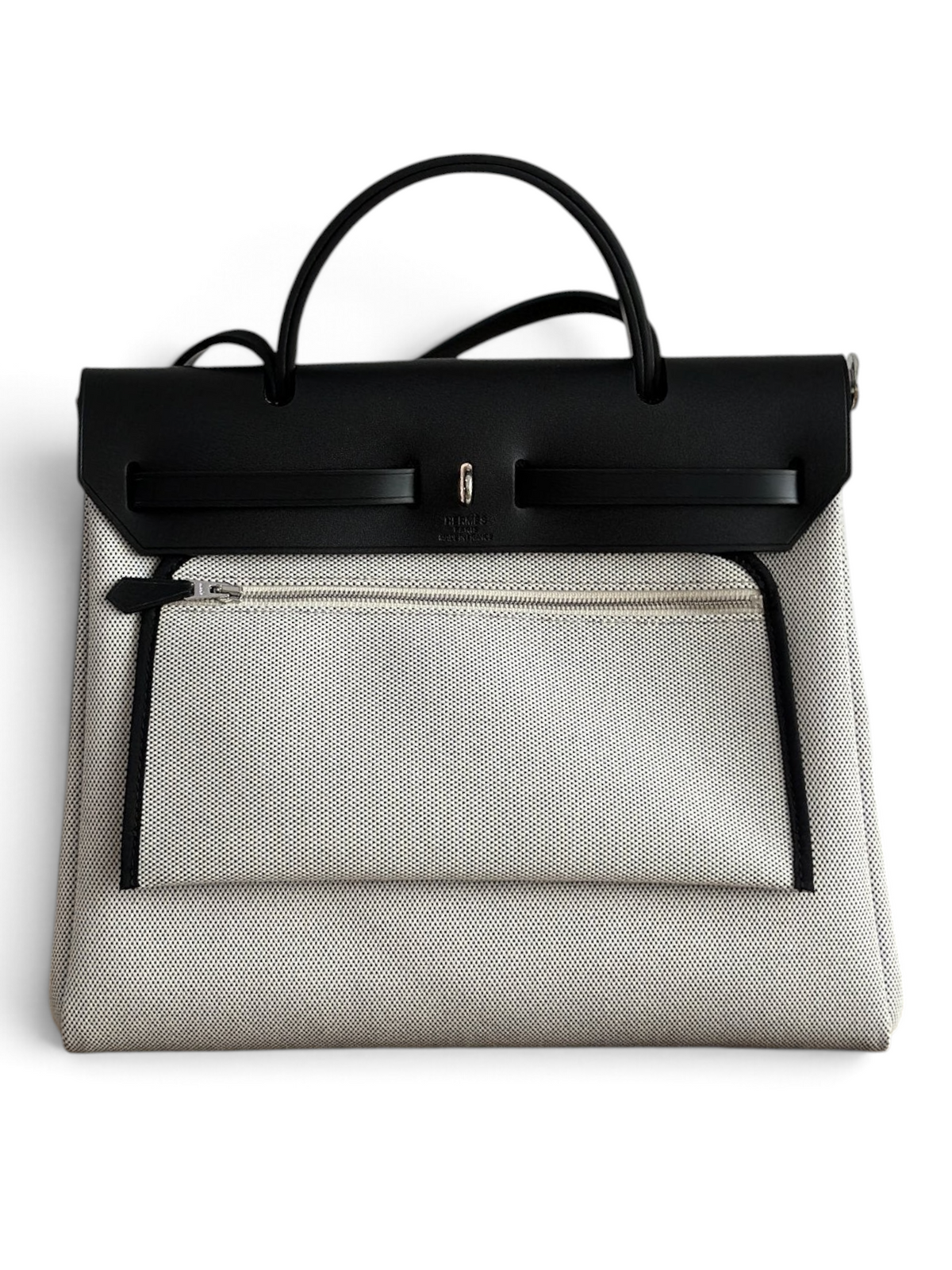 SWORD LUXURY Hermès Herbag 31 çanta, siyah deri kapaklı ve bej kanvas gövdeli, şık ve modern tasarım.
