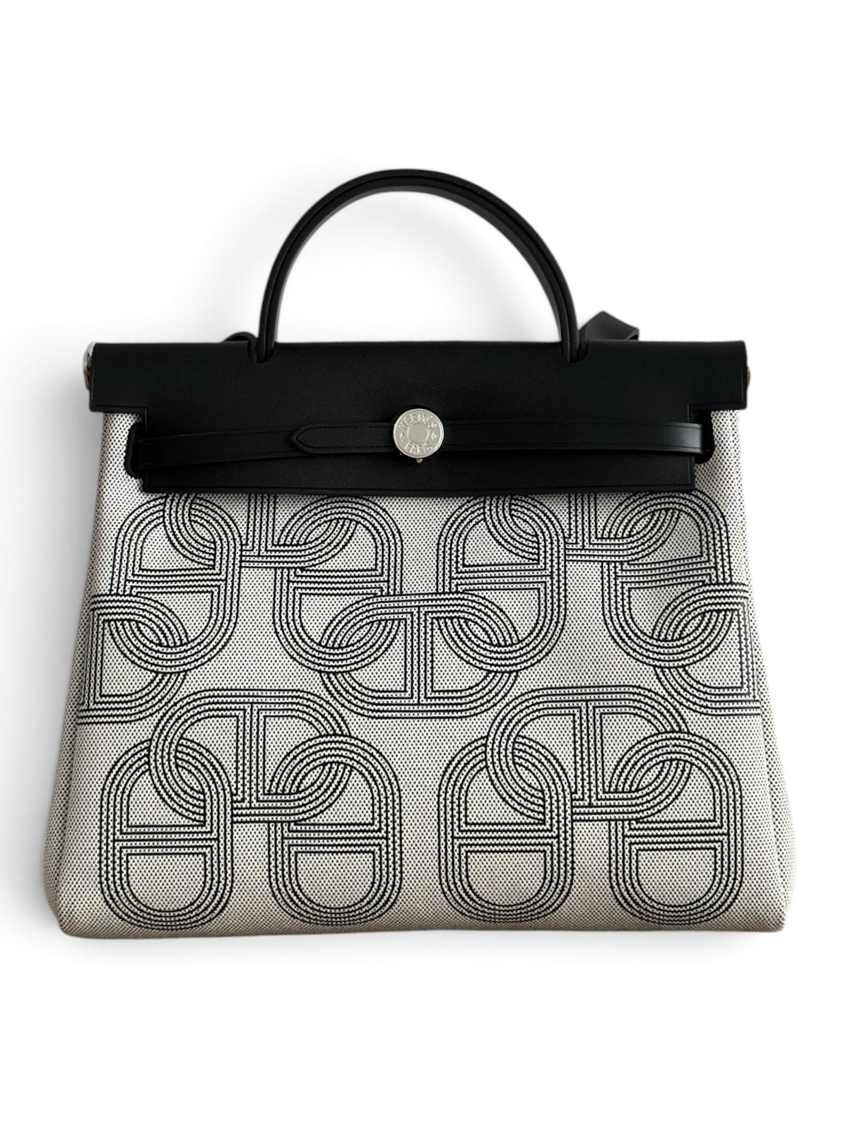 SWORD LUXURY Hermès Herbag 31 çanta, siyah deri kapaklı ve beyaz üzerine siyah desenli kanvas gövdeli, şık tasarım.