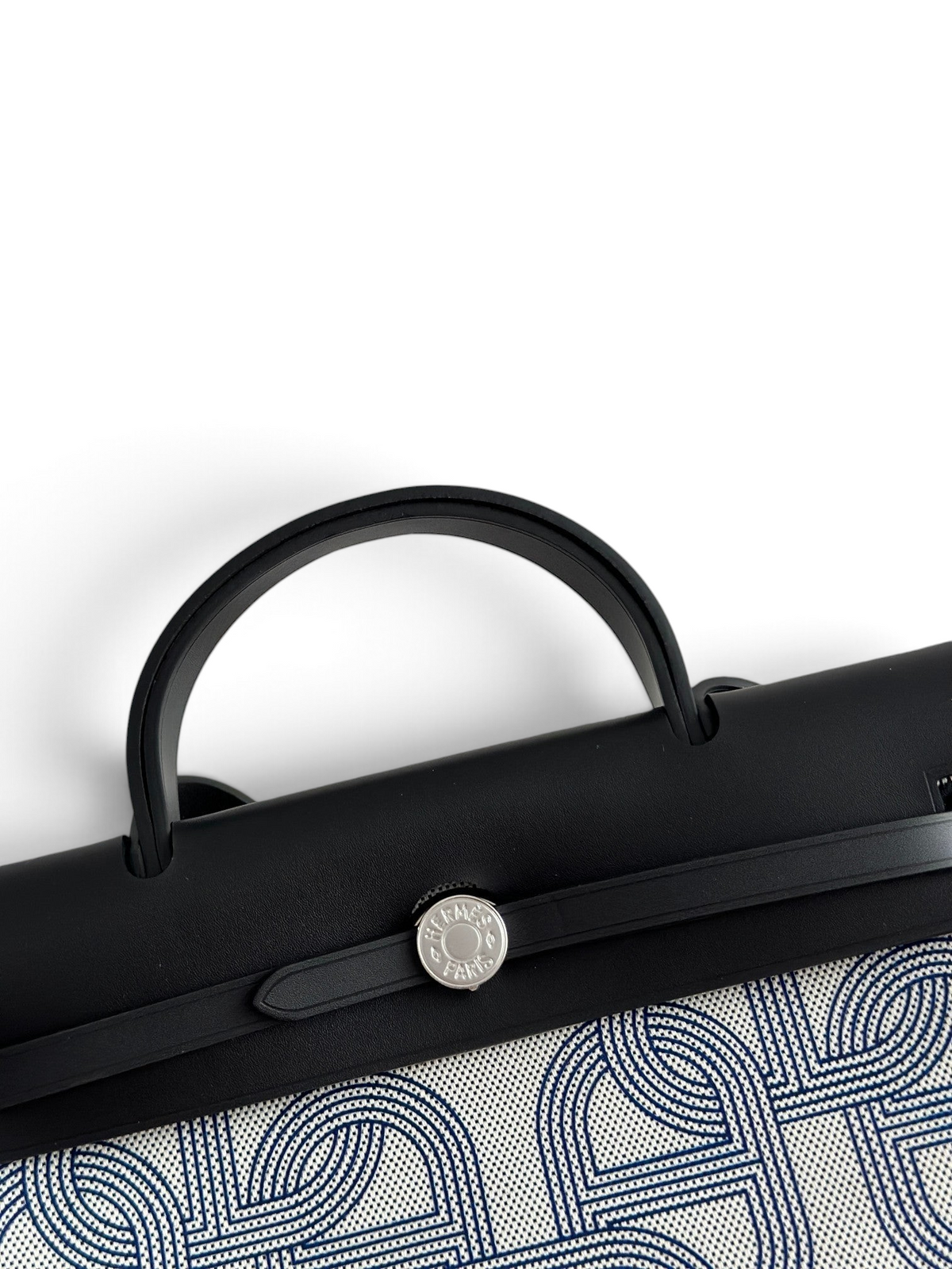 SWORD LUXURY Hermès Herbag 31 çanta, siyah deri kapaklı, Clou de Selle kilitli ve desenli kanvas gövdeli zarif tasarım.