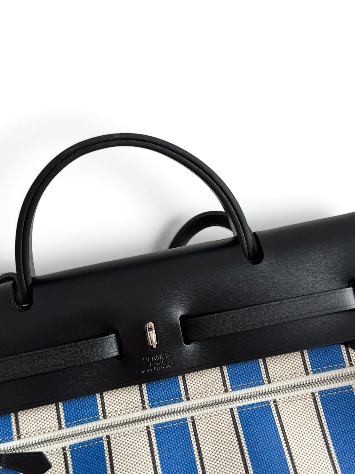 SWORD LUXURY Hermès Herbag 31 çanta, siyah deri kapaklı ve mavi çizgili kanvas gövdeli, Clou de Selle detaylı.