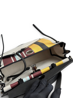 SWORD LUXURY Hermès Herbag 31 çanta, renkli çizgili kanvas gövdesi ve siyah deri detaylarıyla açık görünüm.
