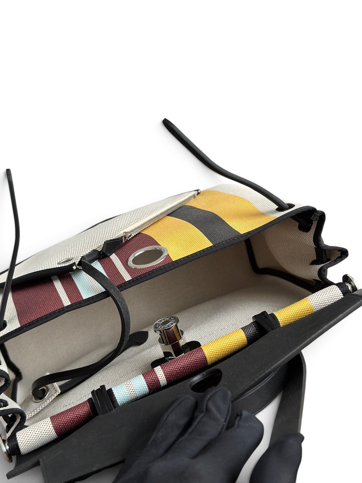 SWORD LUXURY Hermès Herbag 31 çanta, renkli çizgili kanvas gövdesi ve siyah deri detaylarıyla açık görünüm.